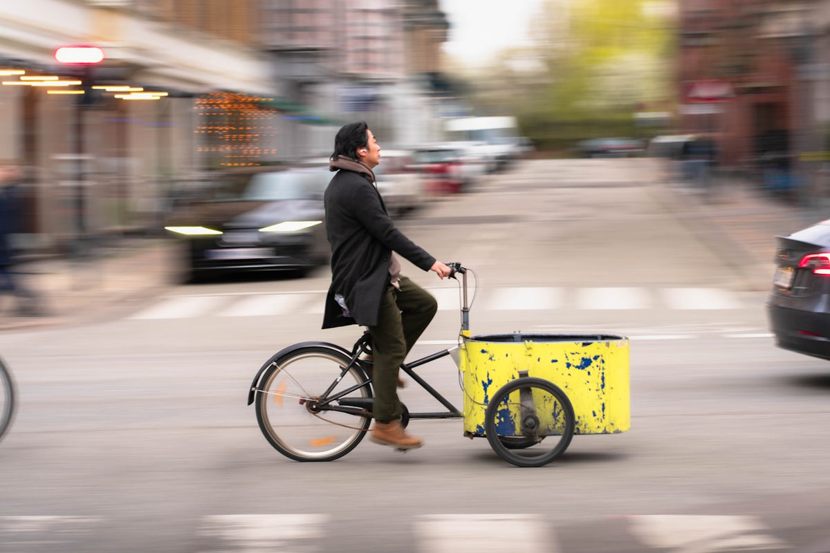 A cargo bike moving through a city street, carrying a delivery